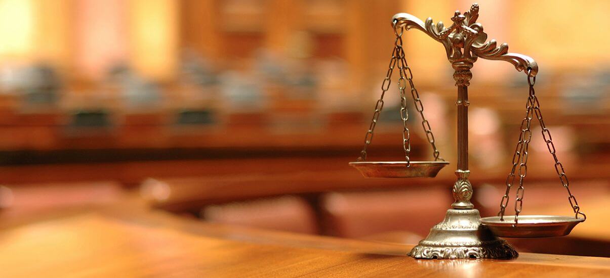 Photo of law library with justice scale