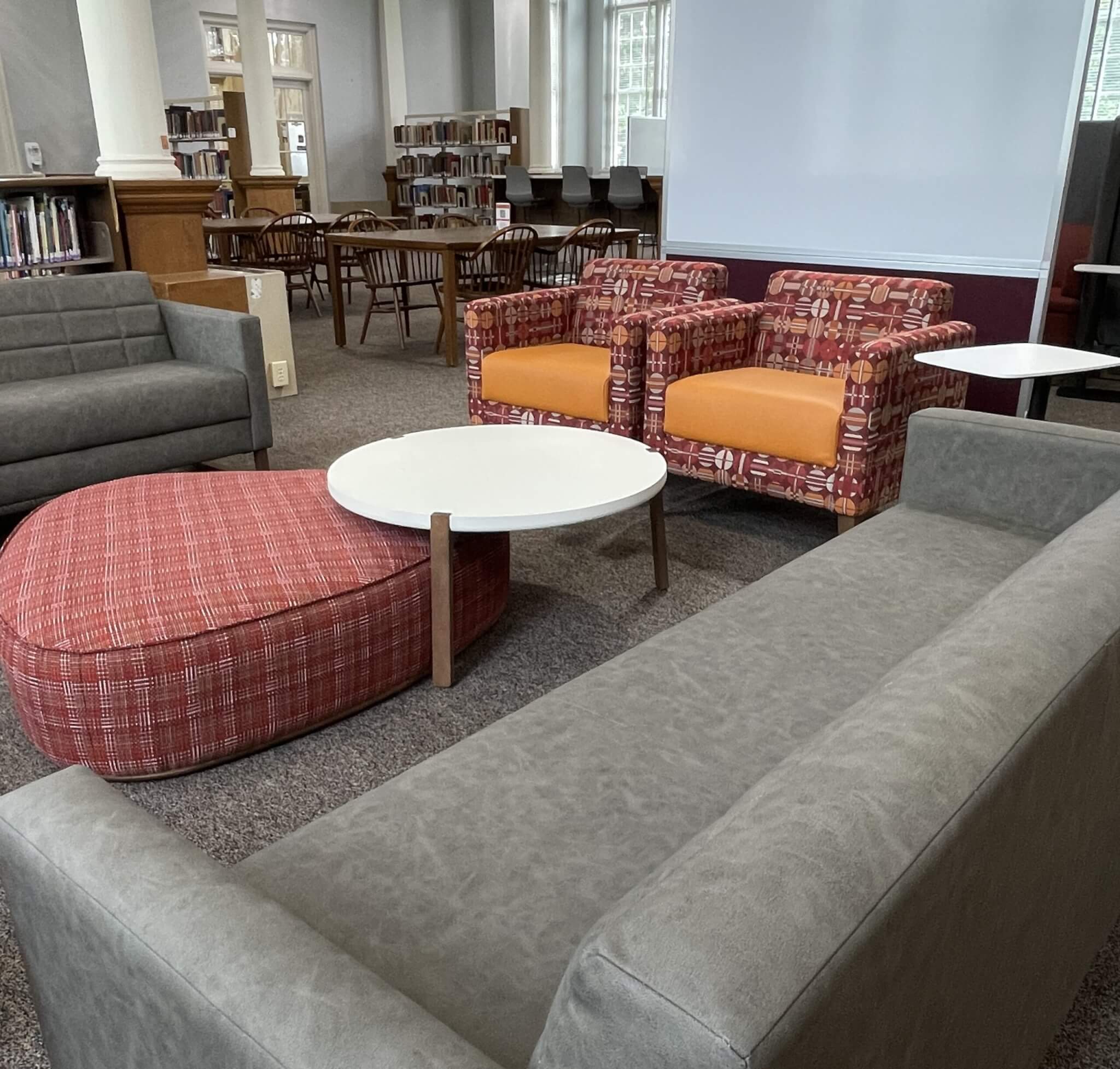 Two gray sofas, two garnet and orange chairs, and a coffee table create a square lounge area for studying.