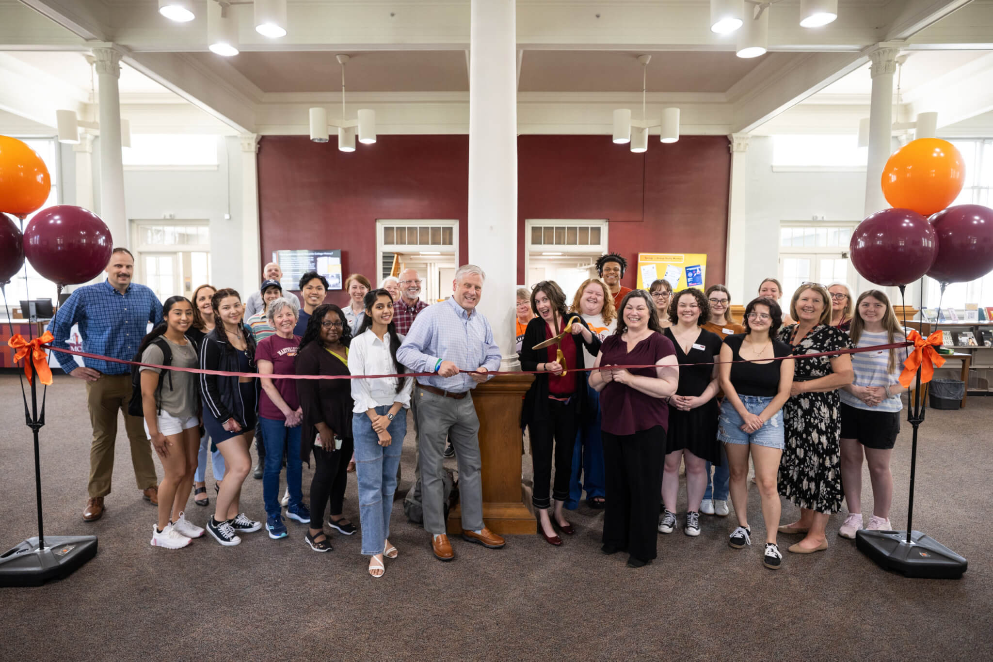 Faculty, staff, and students gather around the ribbon cutting.