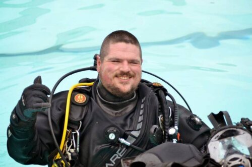 Photo of Michael in a pool wearing a full diving suit