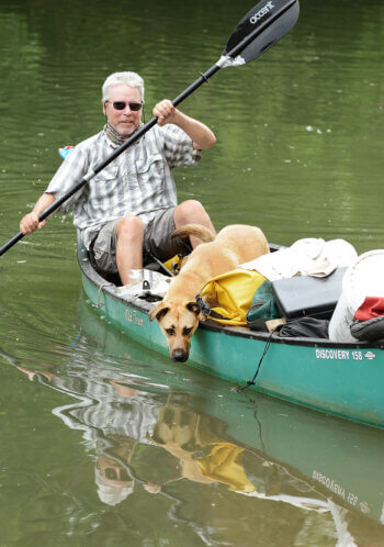 Photo of Kim Trevathan and dog in canoe