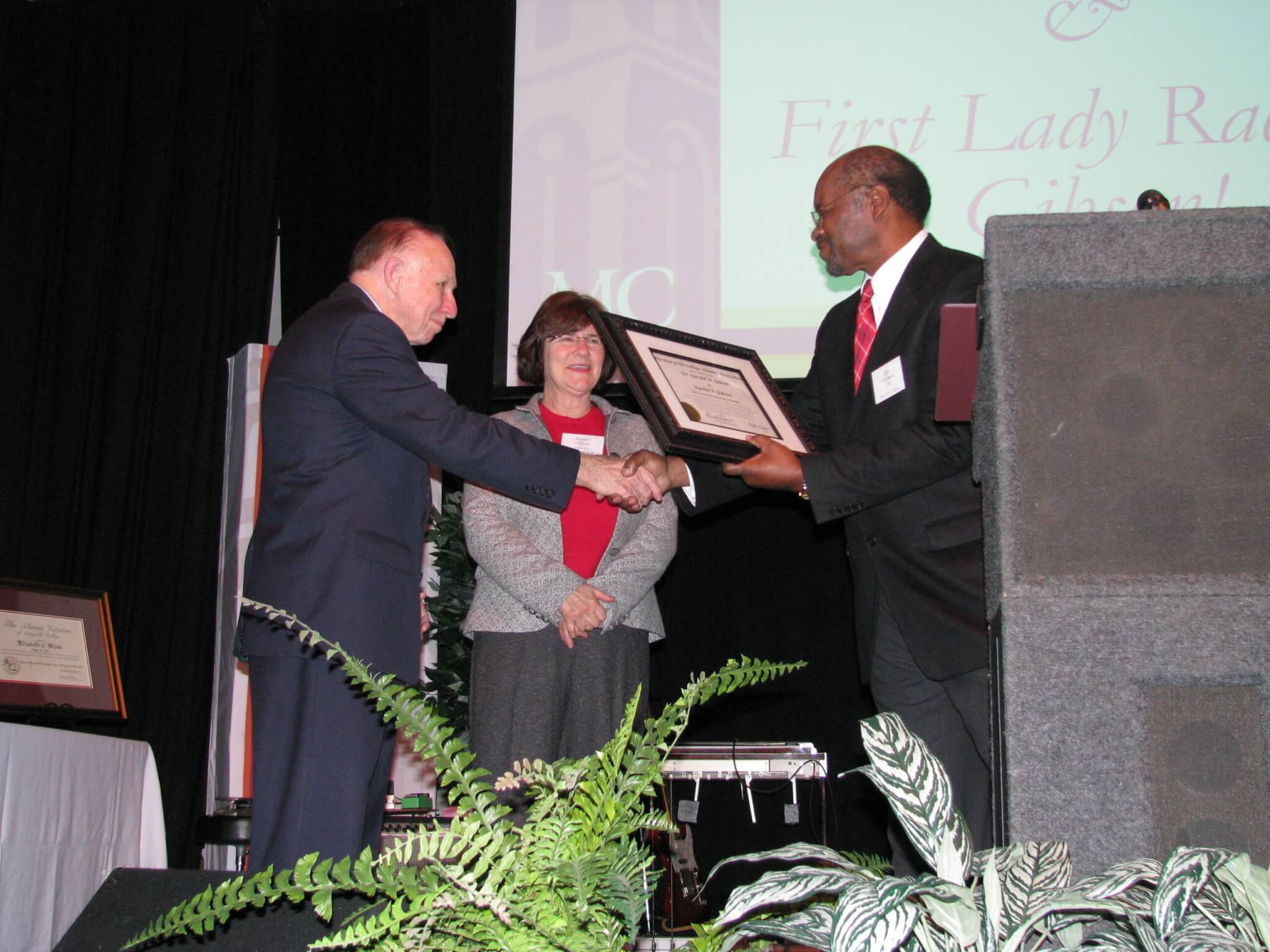 Alumni President Don Hickman ’70 presents Gibsons with honorary alumni plaque.
