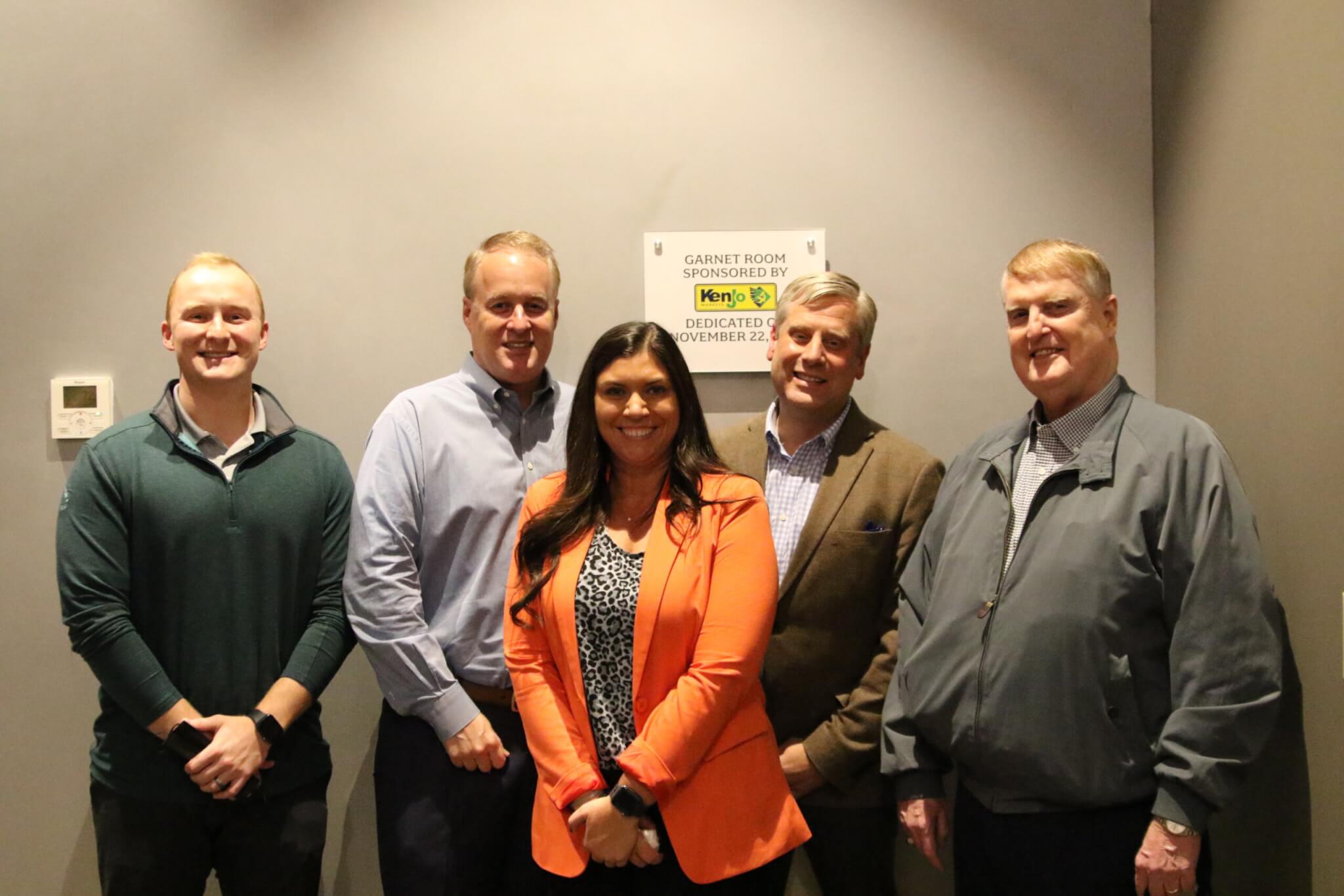 Photo of group in front of sign
