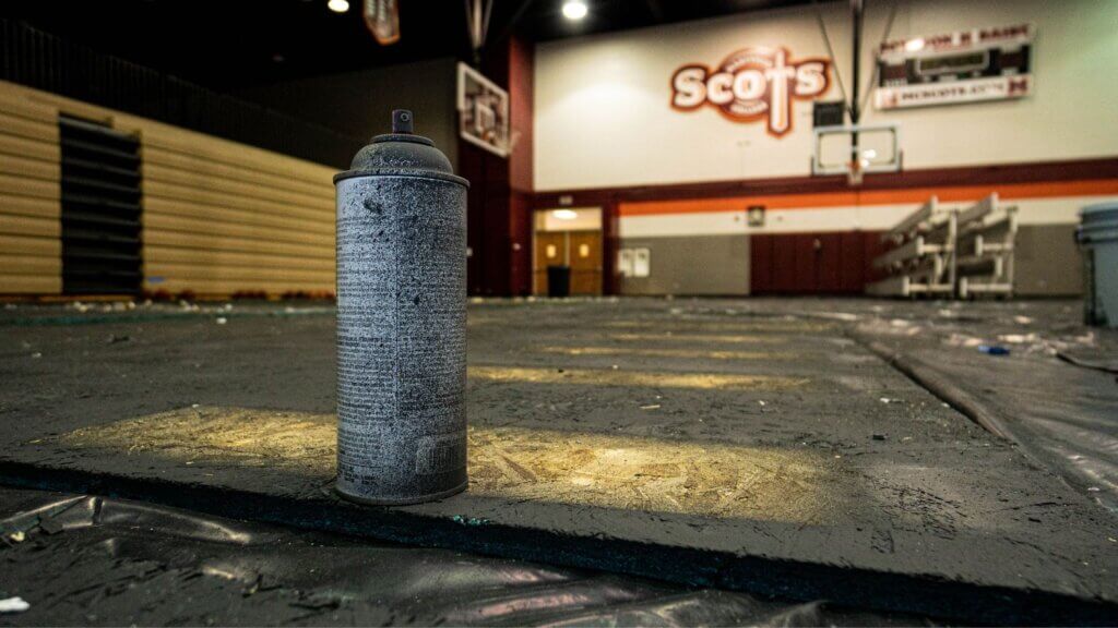 Photo of a spray paint can on the covered floor of the Cooper Athletic Center basketball court