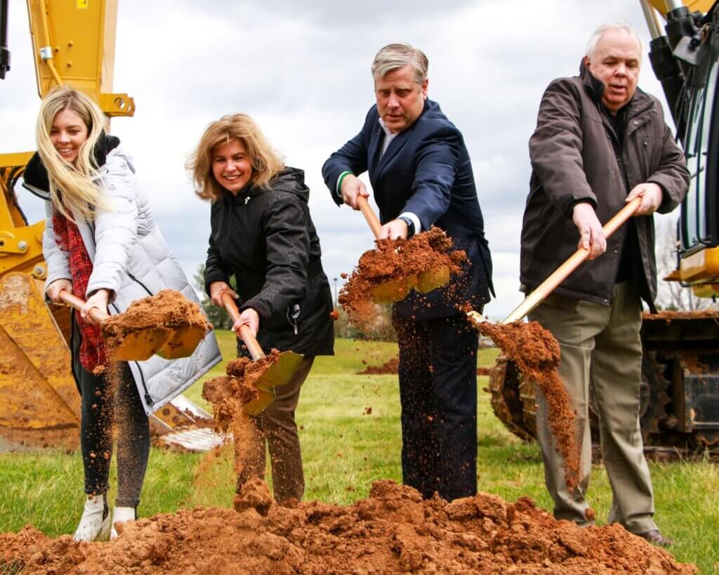 Photo of four people turning over shovels of dirt at the groundbreaking for the Austin Coleman Piper Memorial Track at Maryville College