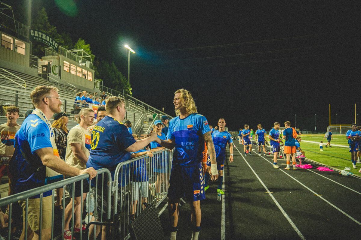Photo of soccer player and fans