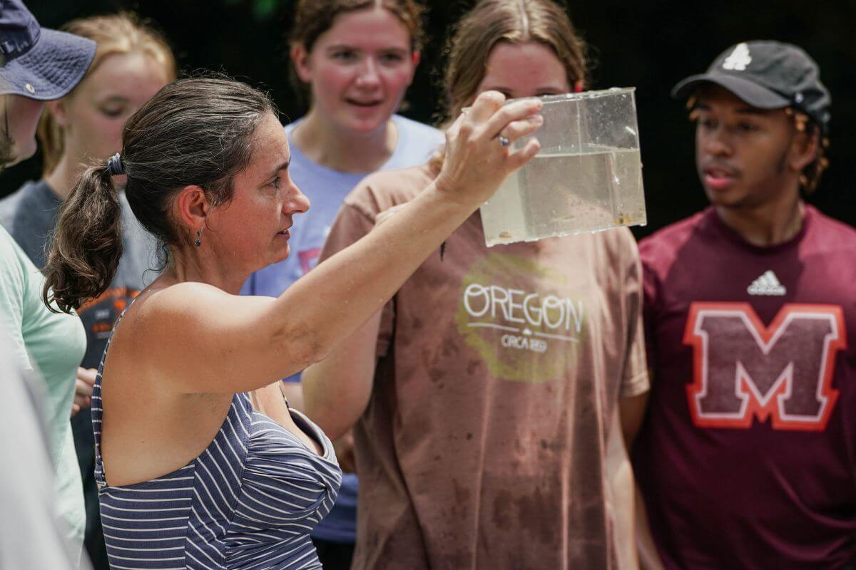 Photo of MC faculty holding up a container of water from the Little River