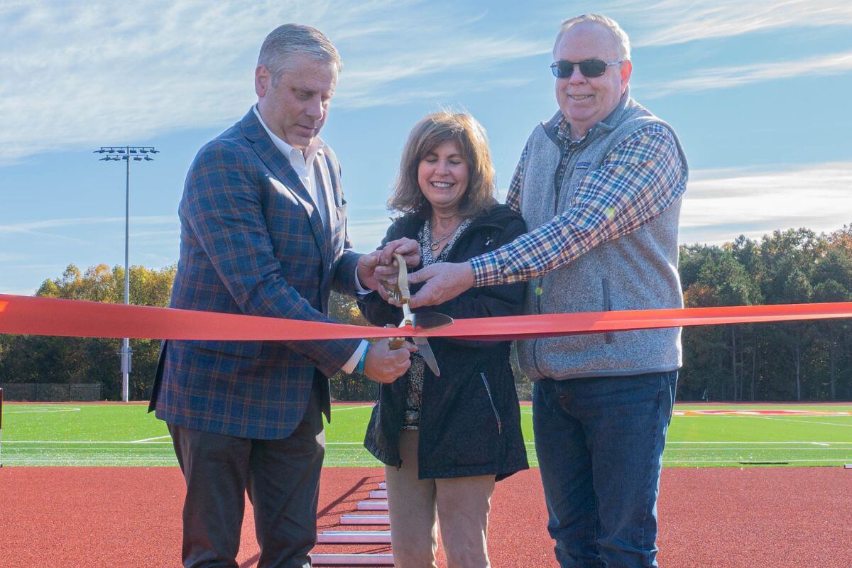 Two people cutting a ribbon at the track dedication.