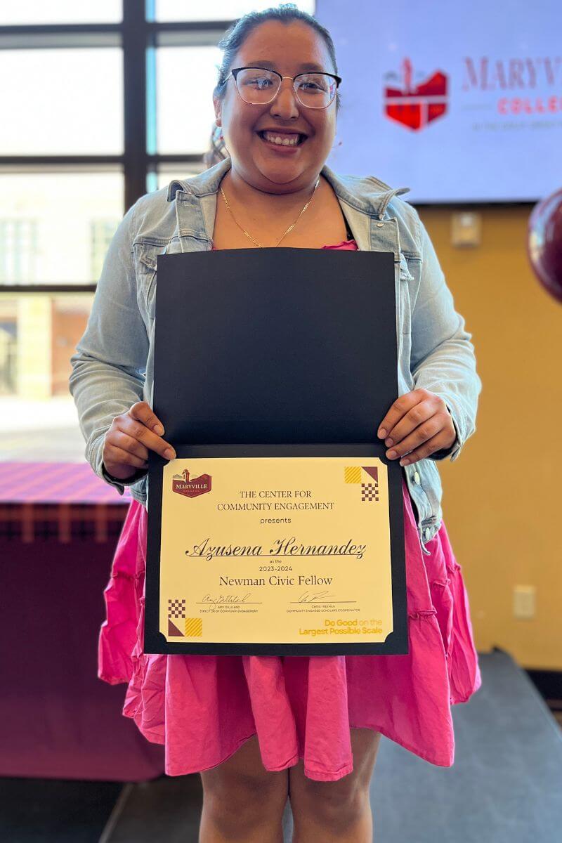 Azusena Hernandez holding a plaque