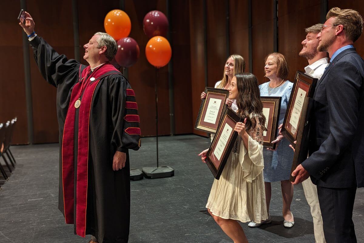 Photo of Dr. Bryan Coker taking a selfie with Outstanding Senior nominees.