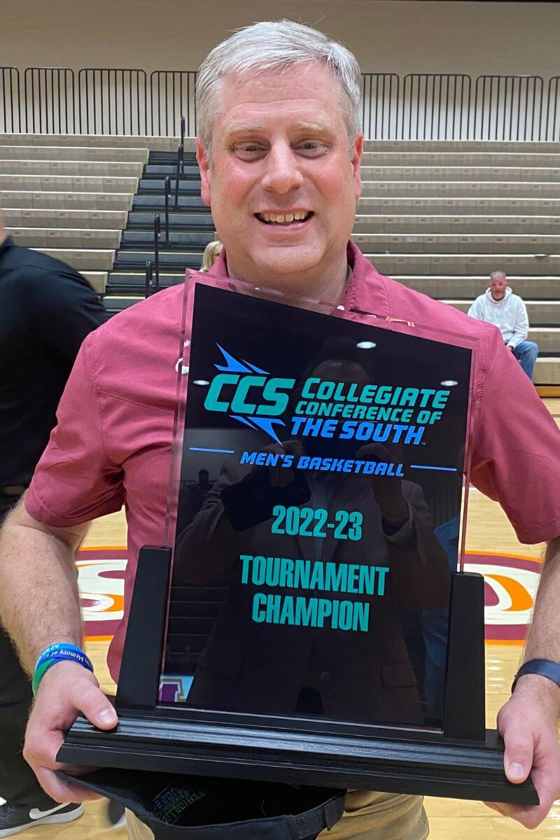 Photo of Dr. Bryan Coker holding the trophy for the CCS tournament