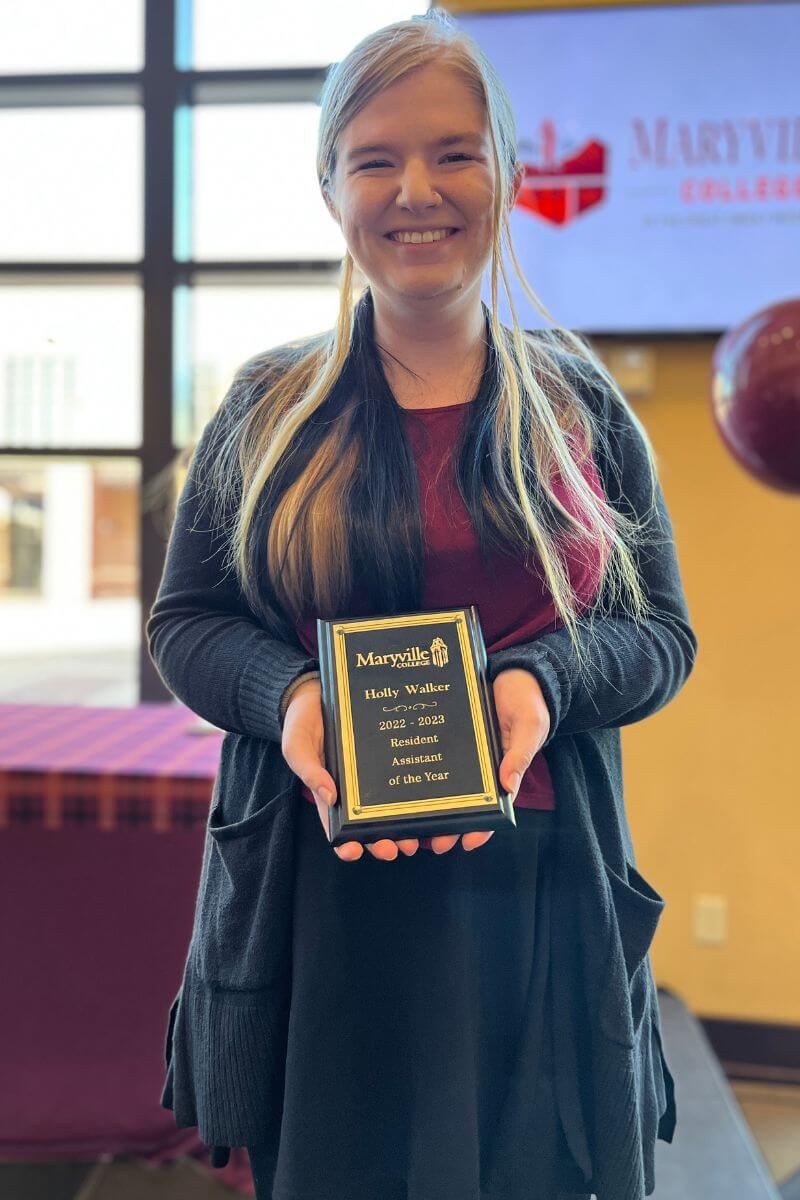 Photo of Holly Walker holding a plaque