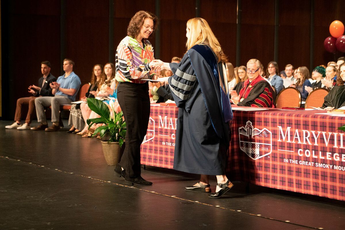 Photo of student Carmela Lewis accepting an award from Dr. Mary Turner