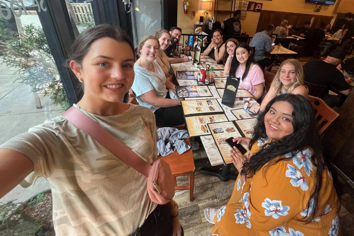 Photo of students of Dr. Zach Himmelberger gathered around a table at a New Orleans restaurant