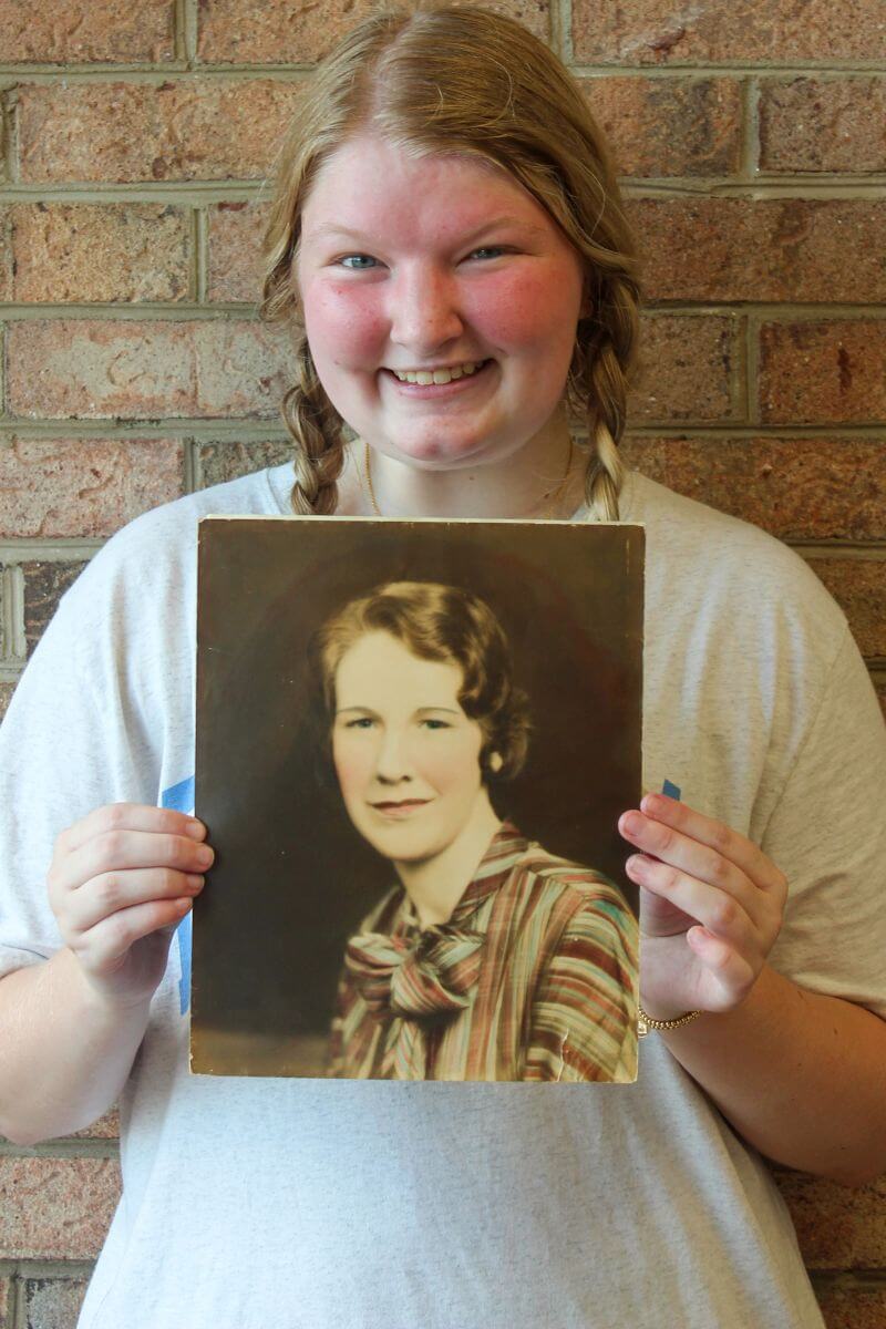 Photo of Gracie Dykes holding a photo of her late great-grandmother.