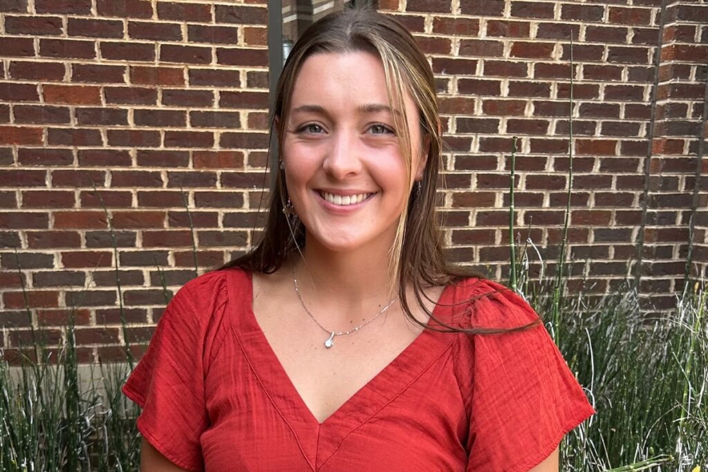 Photo of Sara Koonce smiling in front of a brick wall