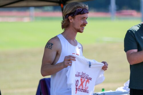 Photo of Steve Cope holding up a monogrammed T-shirt