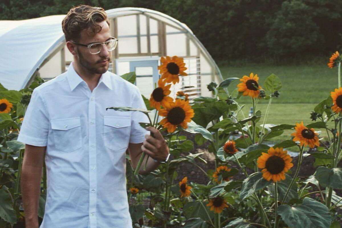 Photo of Kelton Bloxham examining a sunflower