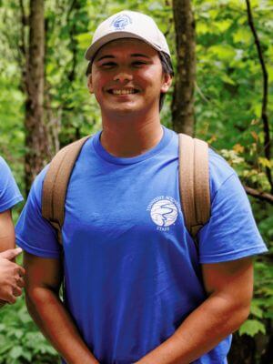 Photo of Alonso Angel 24 standing in the woods and smiling