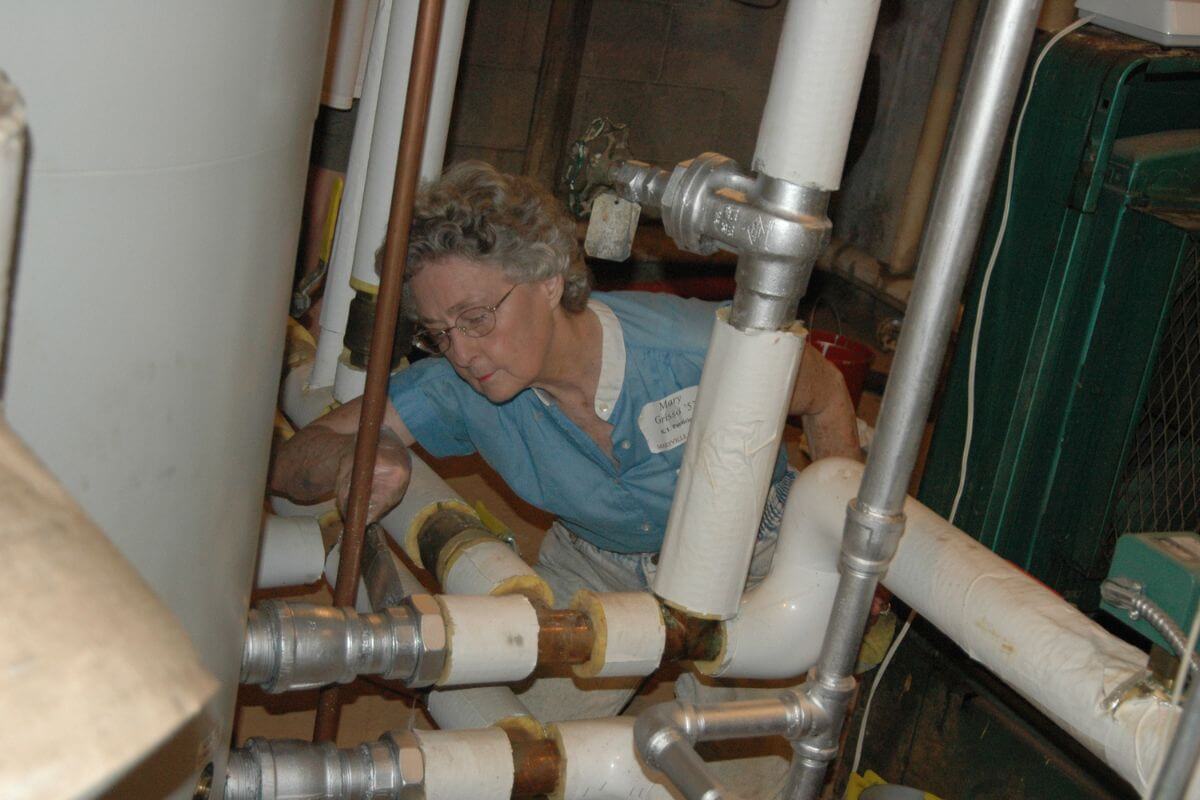 Photo of a female Maryville College alumna working on pipes during KT Days 2005