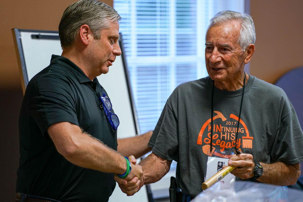 Photo of Dr. Bryan Coker shaking the hand of Dan Greaser '60.