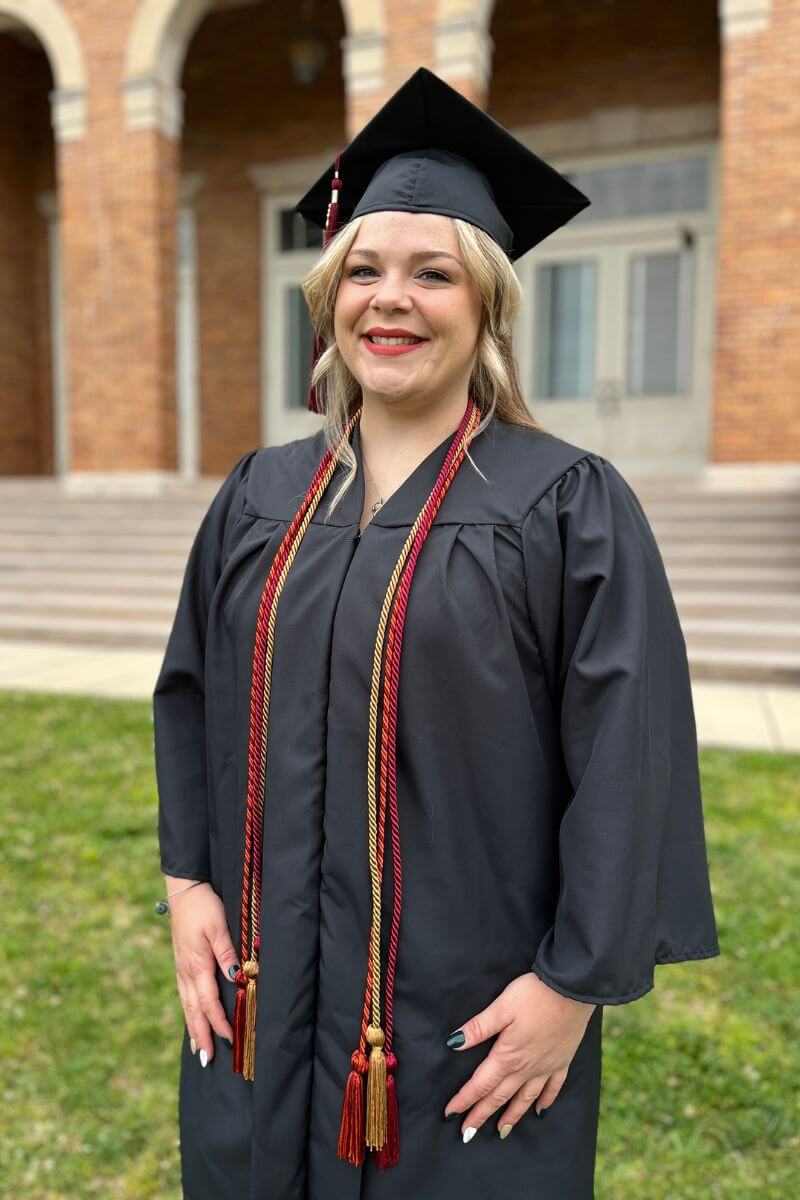 Photo of Khalie Cleveland in her graduation attire in front of the Clayton Center for the Arts