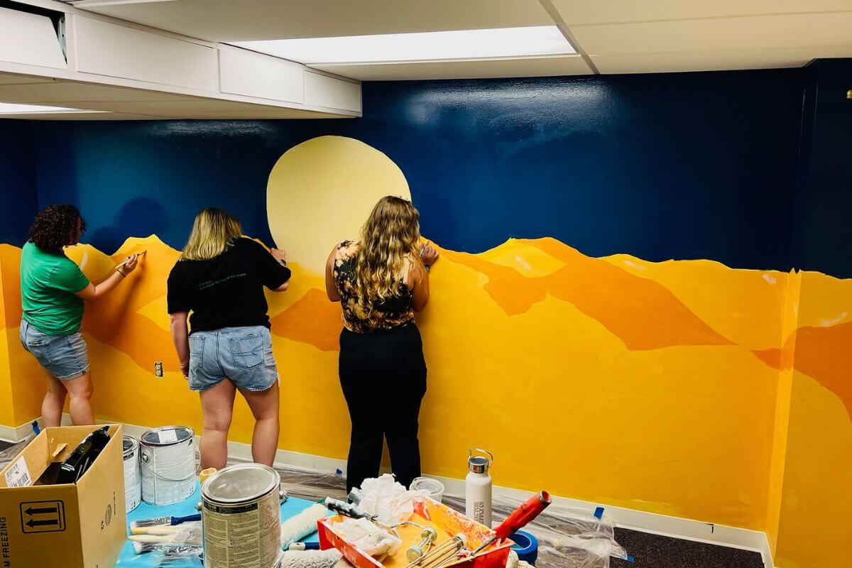 Photo of students painting a mural in the Academic Support Center
