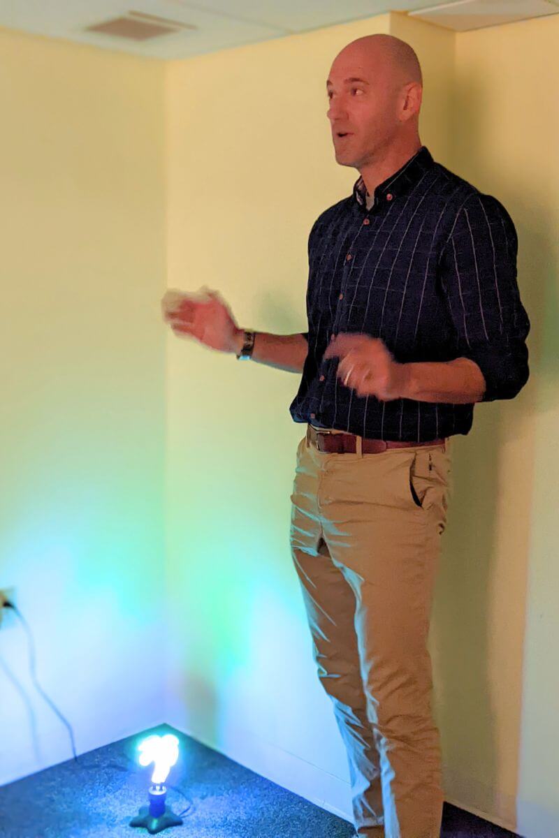 Photo of Noah Bowman standing in a dimly lit room in the Academic Support Center