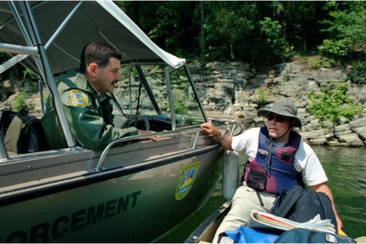 Kim Trevathan talking to a park ranger while the two are in boats