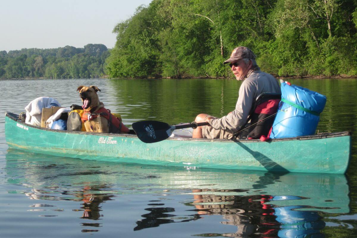 Photo of Kim Trevathan on the Tennessee River in a canoe with Maggie the dog