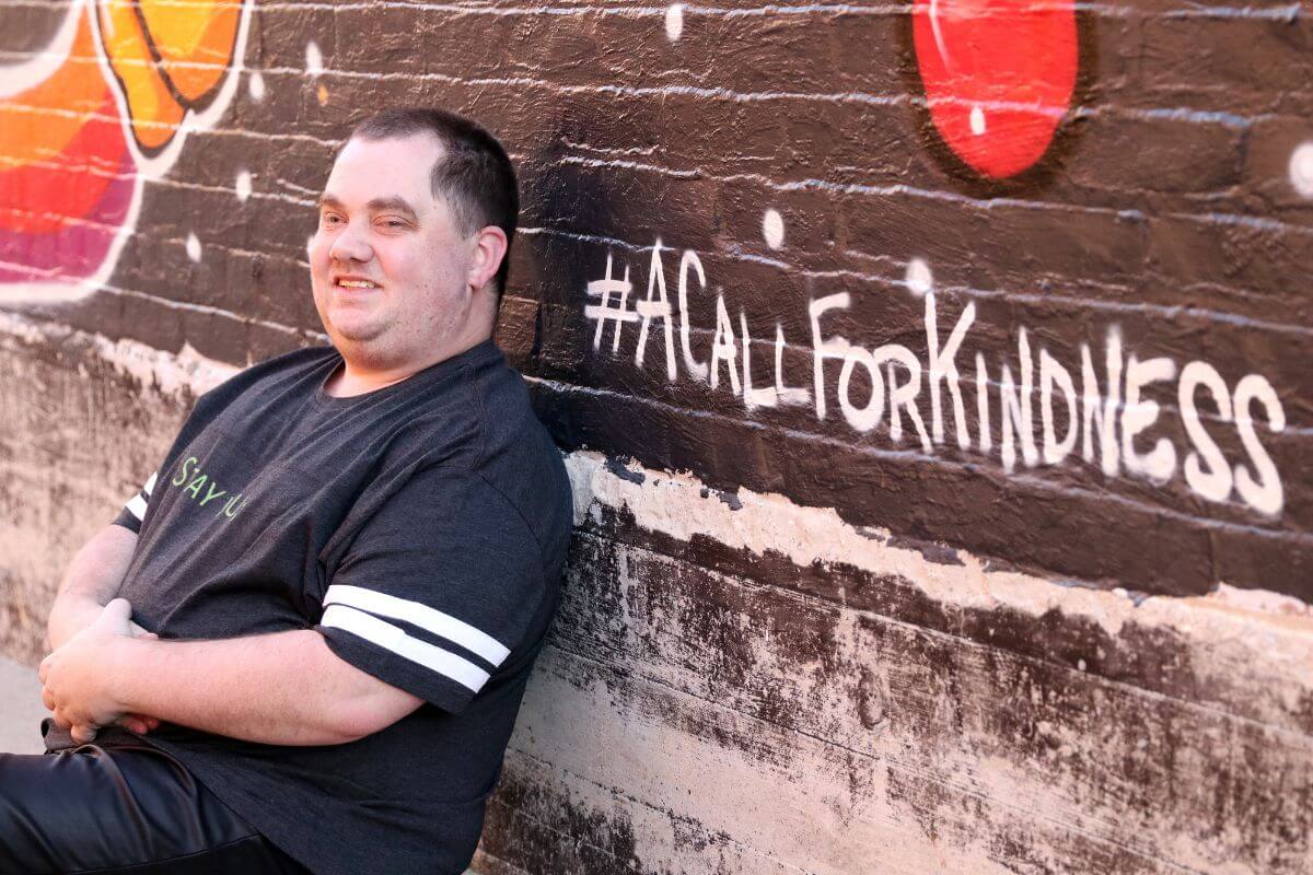 Photo of Ryan Vaughan '14 sitting against a brick wall and smiling