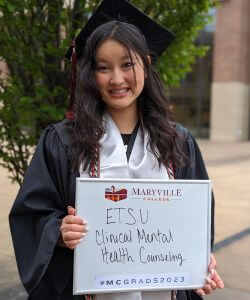 Photo of Abby Garrett in cap and gown at Commencement 2023