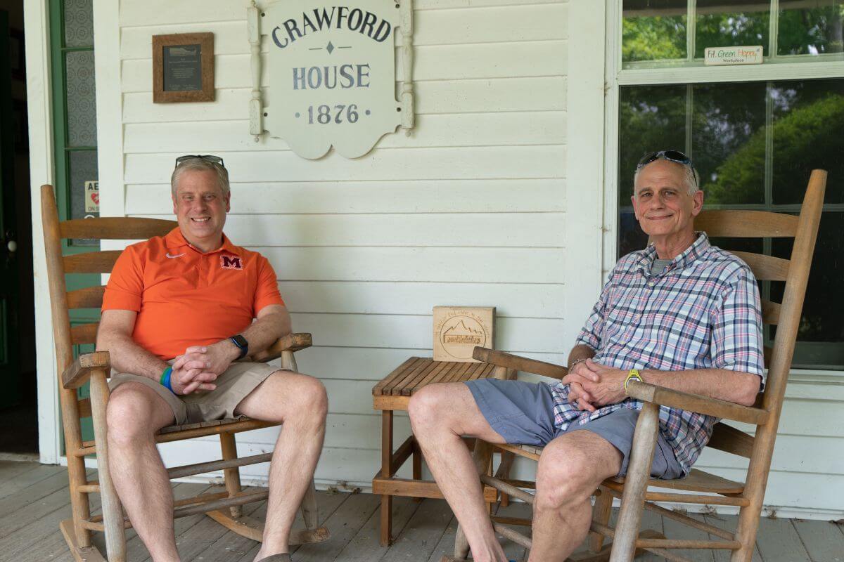 Photo of Bryan Coker and Bruce Guillaume sitting in rocking chairs and smiling