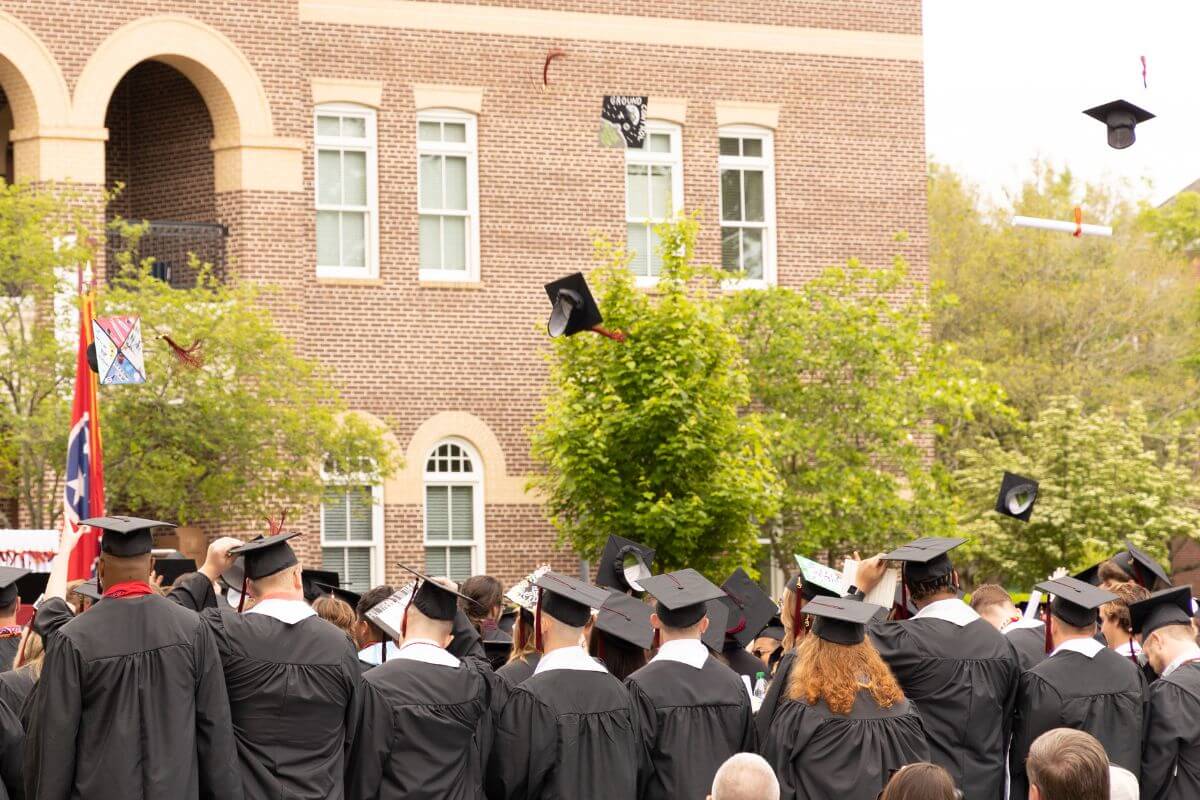 Photo of graduates tossing caps into the air at Commencement 2023