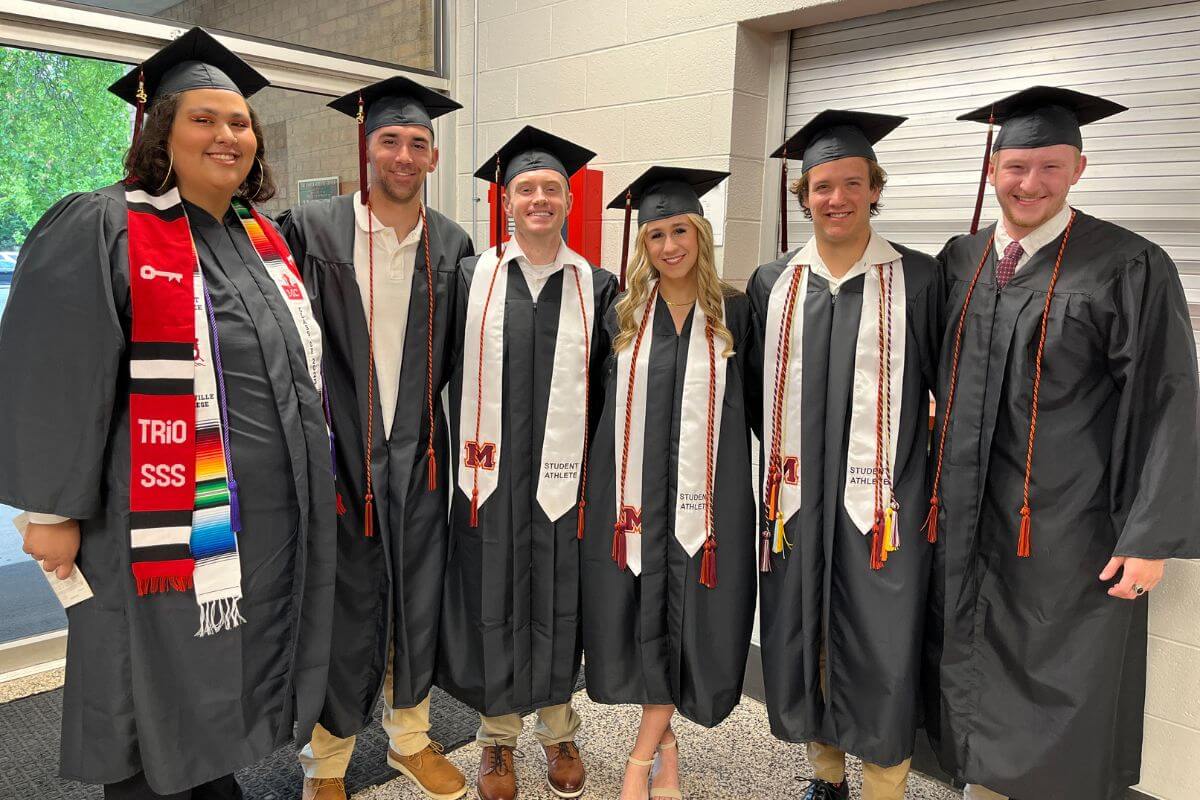 Photo of five Maryville College seniors in their caps and gowns