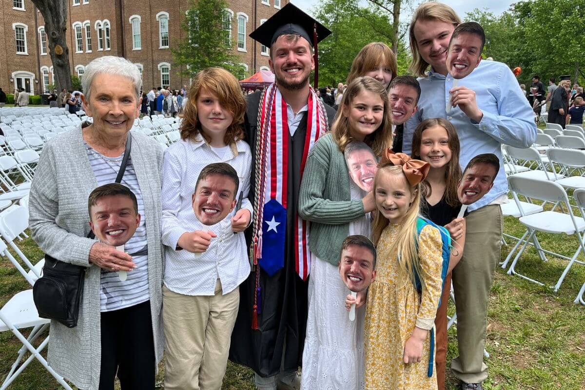 Photo of graduate Kris Seiber and his family on the campus lawn after the 2023 Maryville College Commencement ceremony