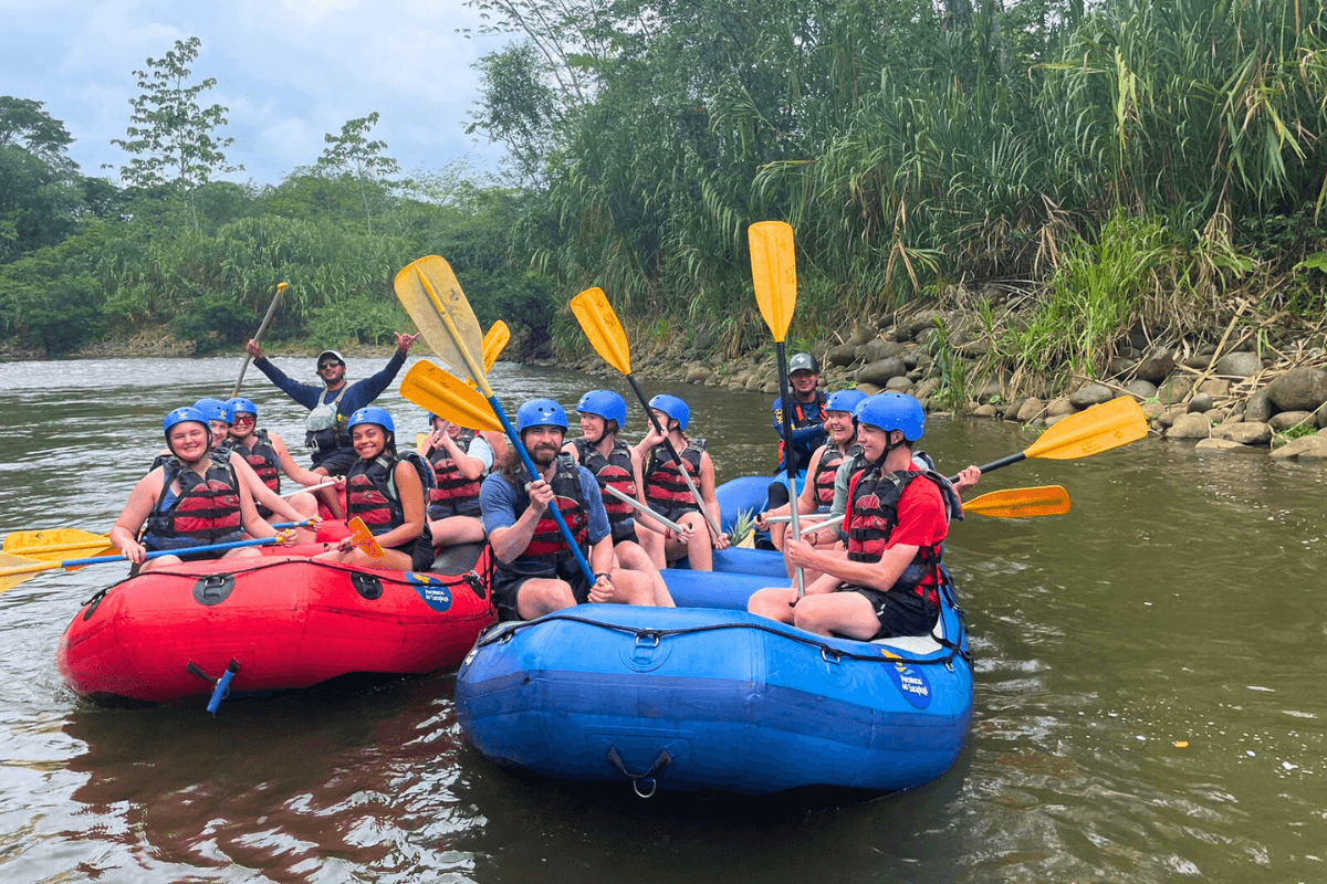 Two boats in a river. In each boat, there are six Maryville College students in each