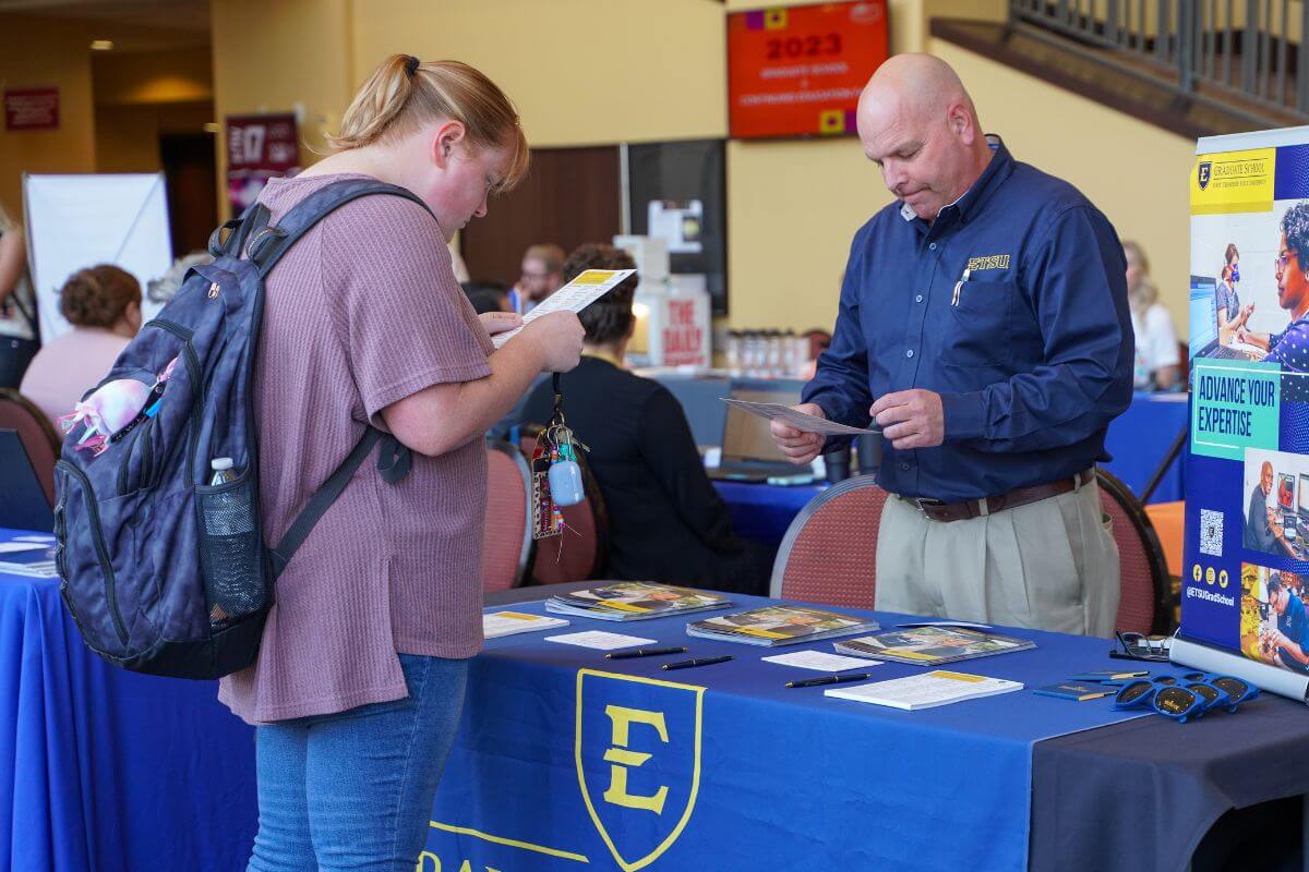 Photo of a representative of ETSU talking with a Maryville College Student