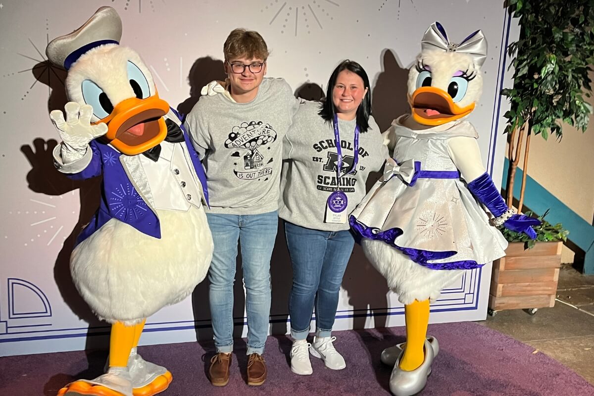 Photo of Austin Zettle with Disney characters