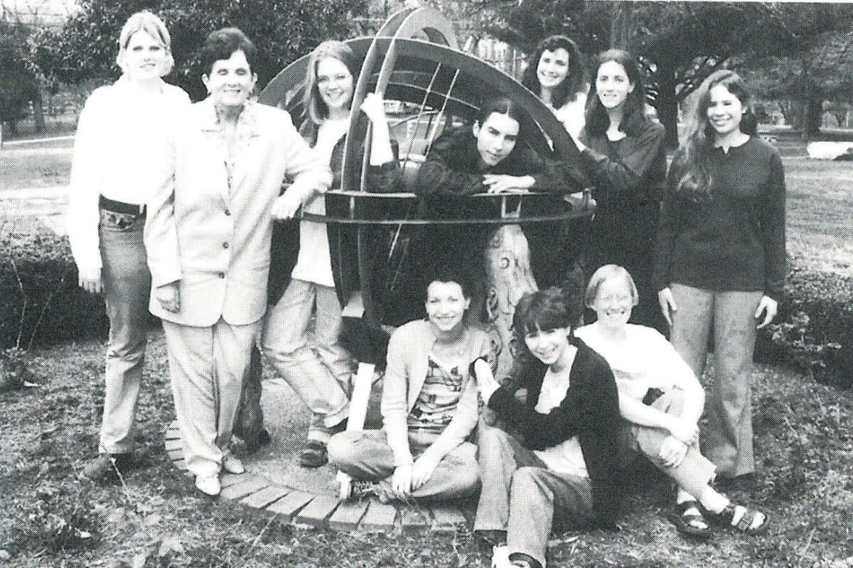 Black-and-white photo of Dr. Charlotte Beck with the staff of Impressions in 1997