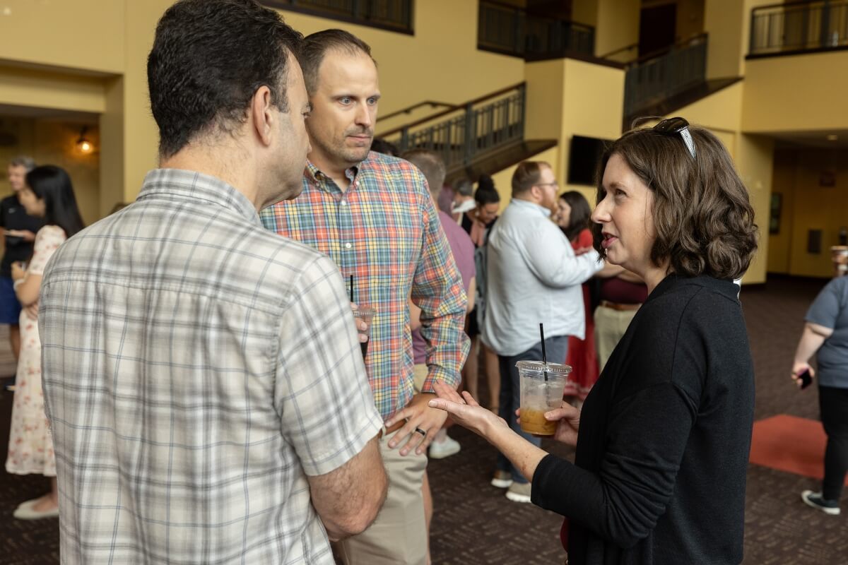 Phot of Doug Sofer, Niklas Trzaskowski and Liz Perry-Sizemore chatting