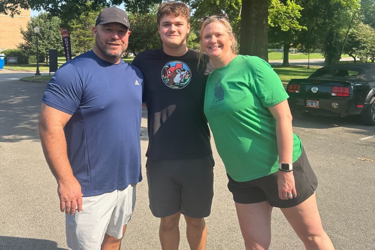 Photo of Josh Lay with parents Jason Lay '97 and Katie Brehmer Lay '99.