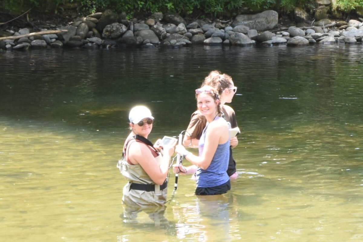 Photo of three Maryville College students standing in the Little River
