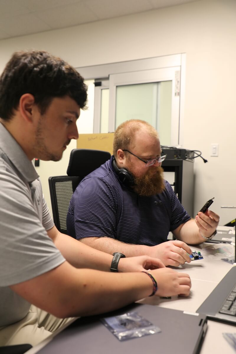 Photo or Nathan Reagan '26 and Luke Koch '20 in an ORNL lab