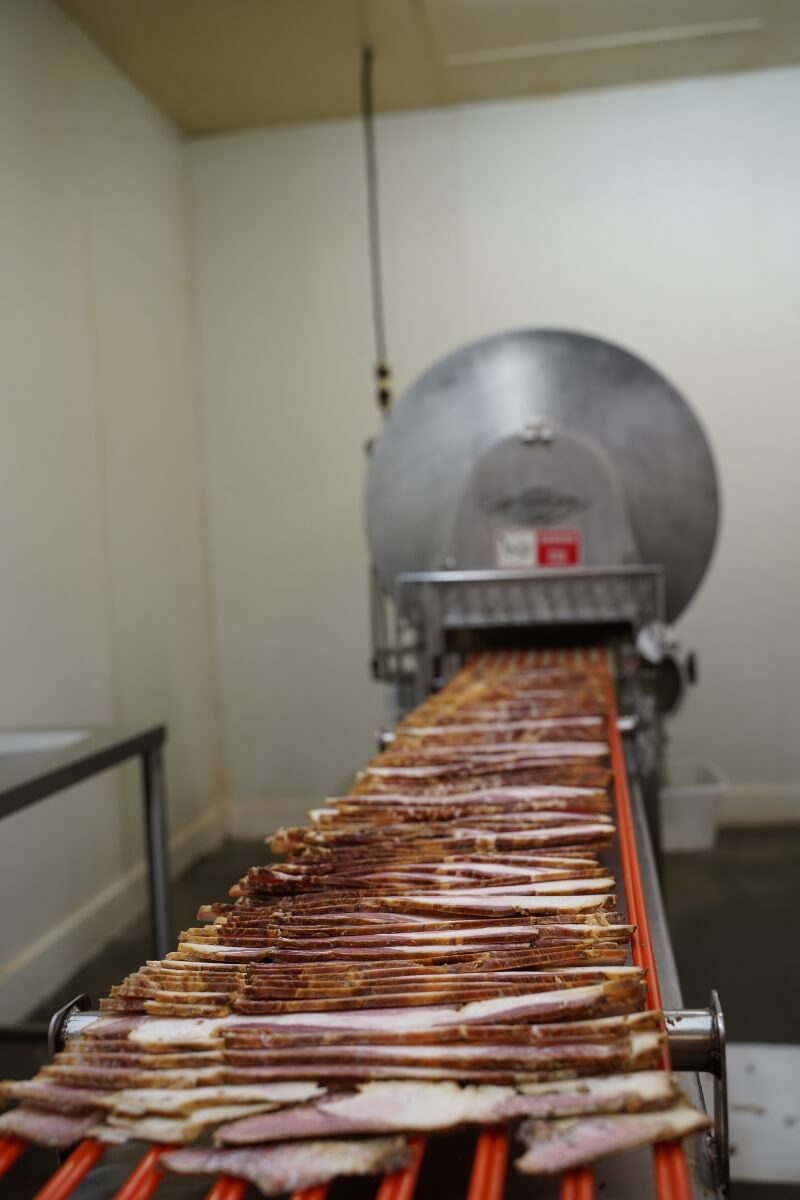 Photo of bacon rolling off a dryer