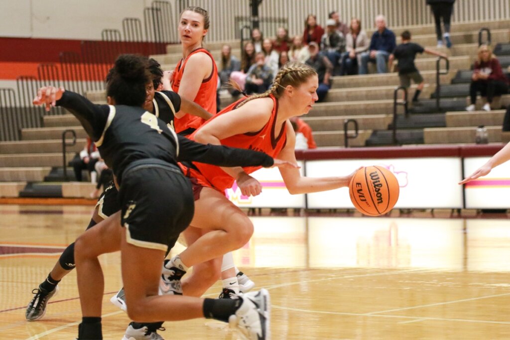 Photo of Ella Tharpe '27 driving with the basketball.
