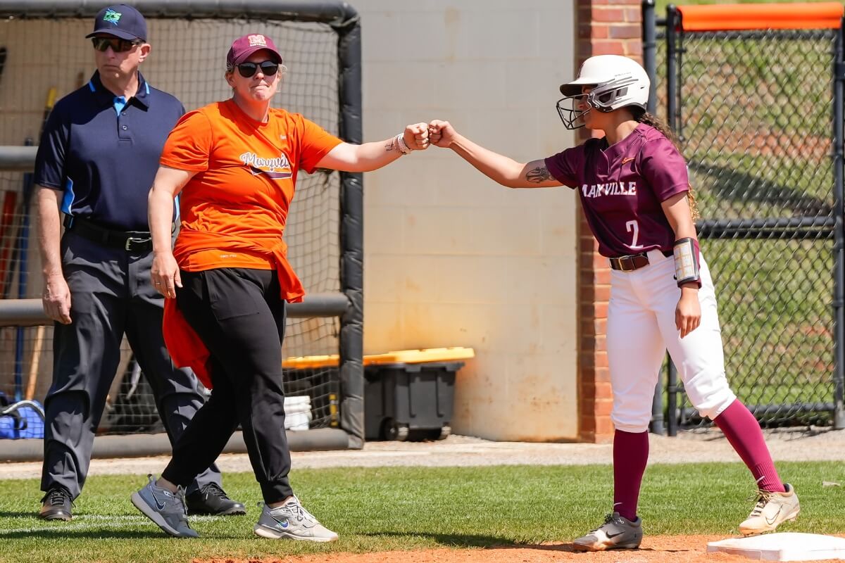 Photo of Coach Jill Moore fist-bumping Cierra Hudson '24.