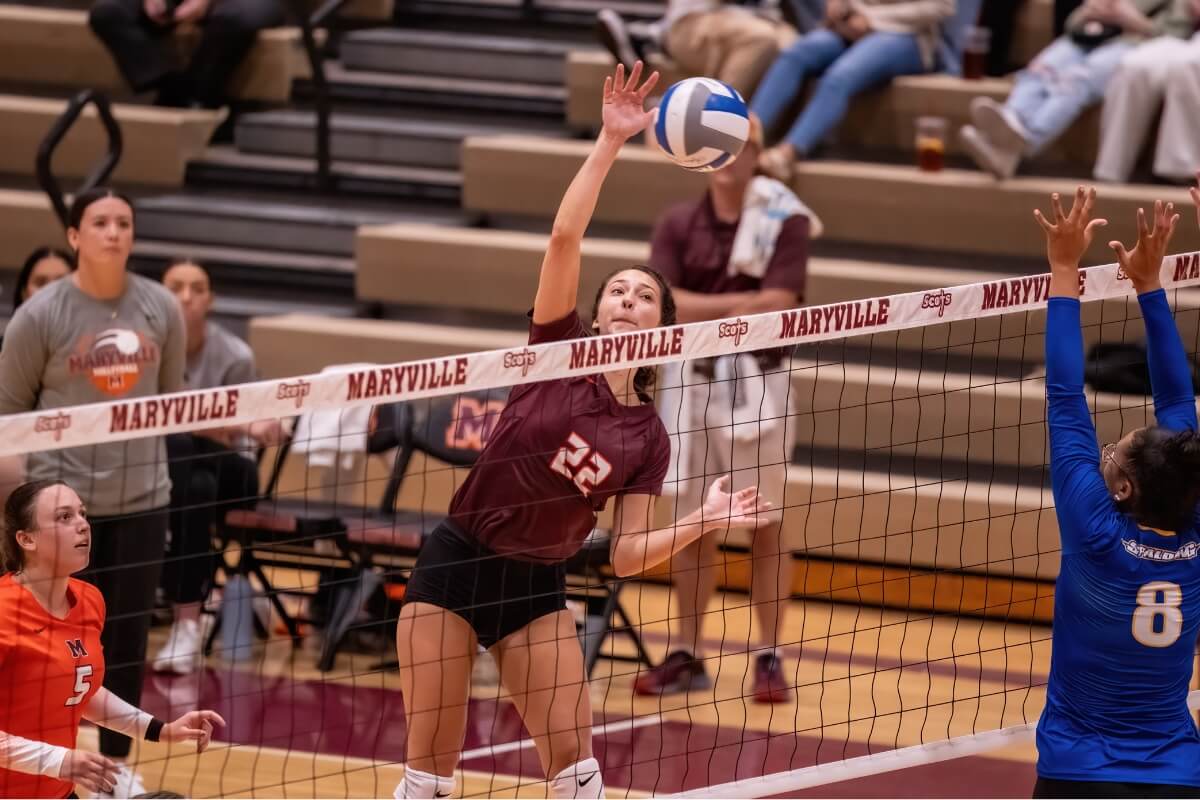 Photo of Landry Frisch '25 spiking a volleyball