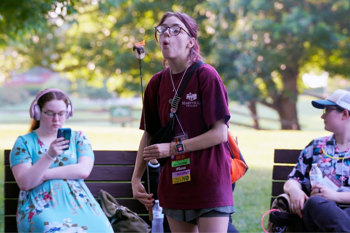 Photo of a girl blowing on a hot marshmallow