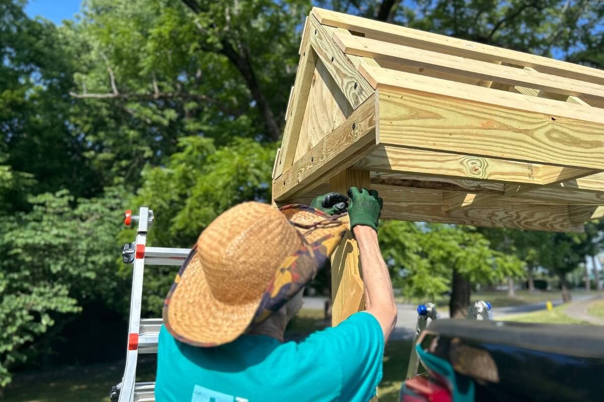 Photo of KT Days volunteer working on a kiosk for the MC Woods
